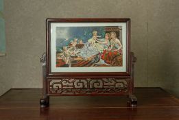 A PORCELAIN AND CARVED WOOD TABLE SCREEN