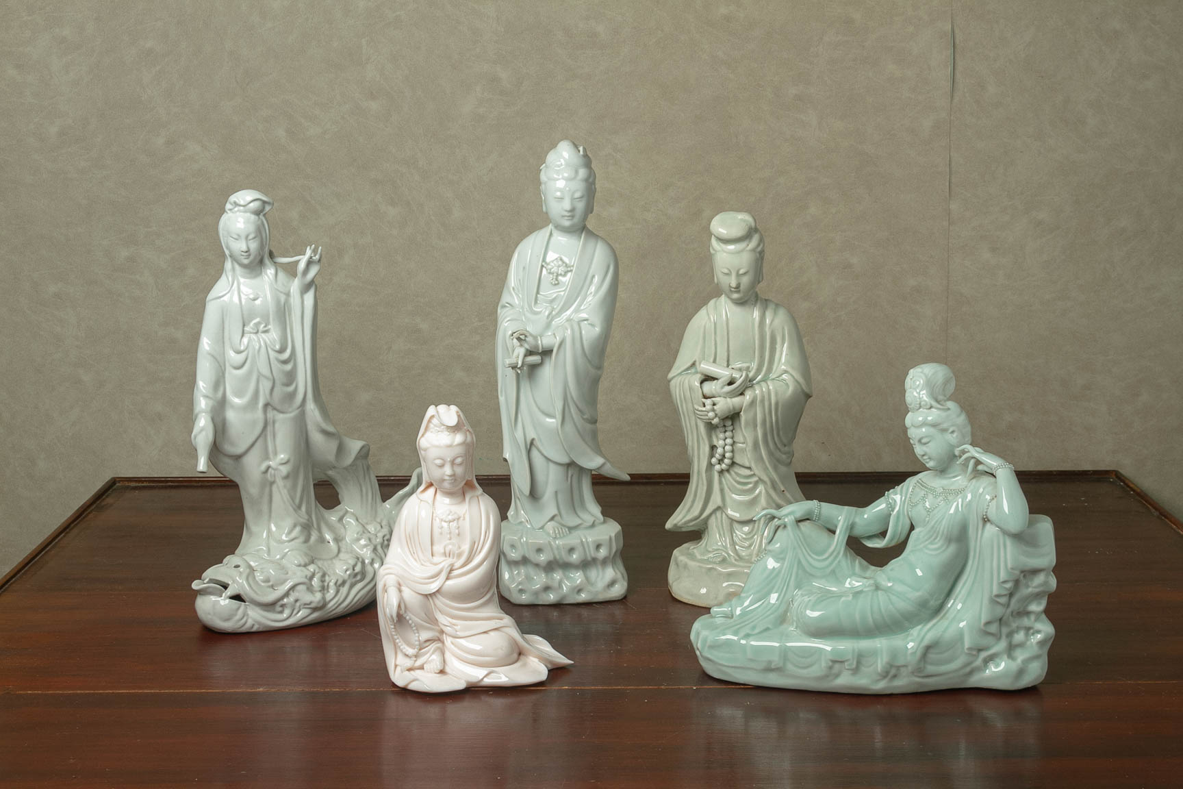 FIVE BLANC DE CHINE AND GREEN GLAZED FIGURES OF GUANYIN