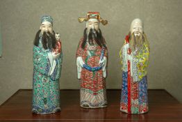 A SET OF THREE FAMILLE ROSE FU LU SHOU FIGURES