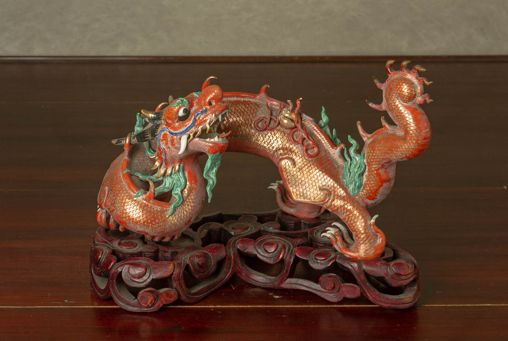 A CORAL GROUND PORCELAIN MODEL OF A DRAGON