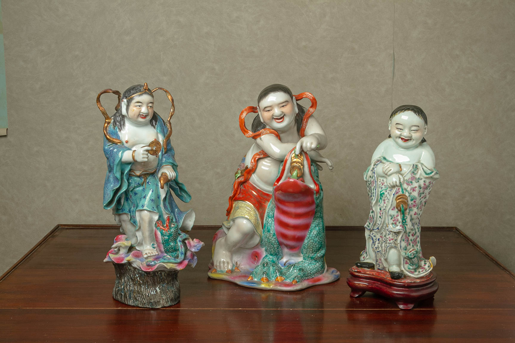 THREE FAMILLE ROSE PORCELAIN FIGURES OF LIU HAI