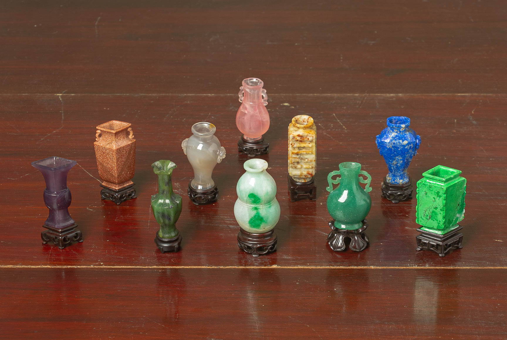 A SET OF TEN MINIATURE CARVED HARDSTONE VASES