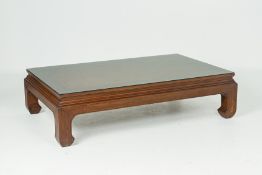 A LARGE RATTAN TOPPED COFFEE TABLE