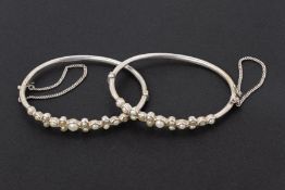 A PAIR OF SILVER AND SEED PEARL BANGLES