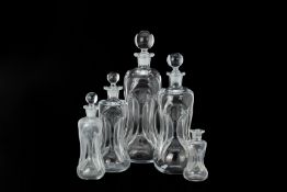 A SET OF FIVE GRADUATED GLASS 'GLUG-GLUG' DECANTERS