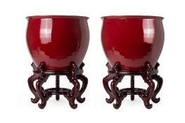 A PAIR OF LARGE SANG DE BOEUF GLAZED JARDINIERES ON STANDS