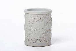 A WHITE GLAZED RELIEF DECORATED BRUSH POT