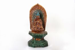 A CHINESE POTTERY FIGURE OF BUDDHA ON STAND