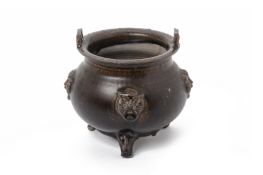A BROWN GLAZED TWIN HANDLED POTTERY TRIPOD CENSER