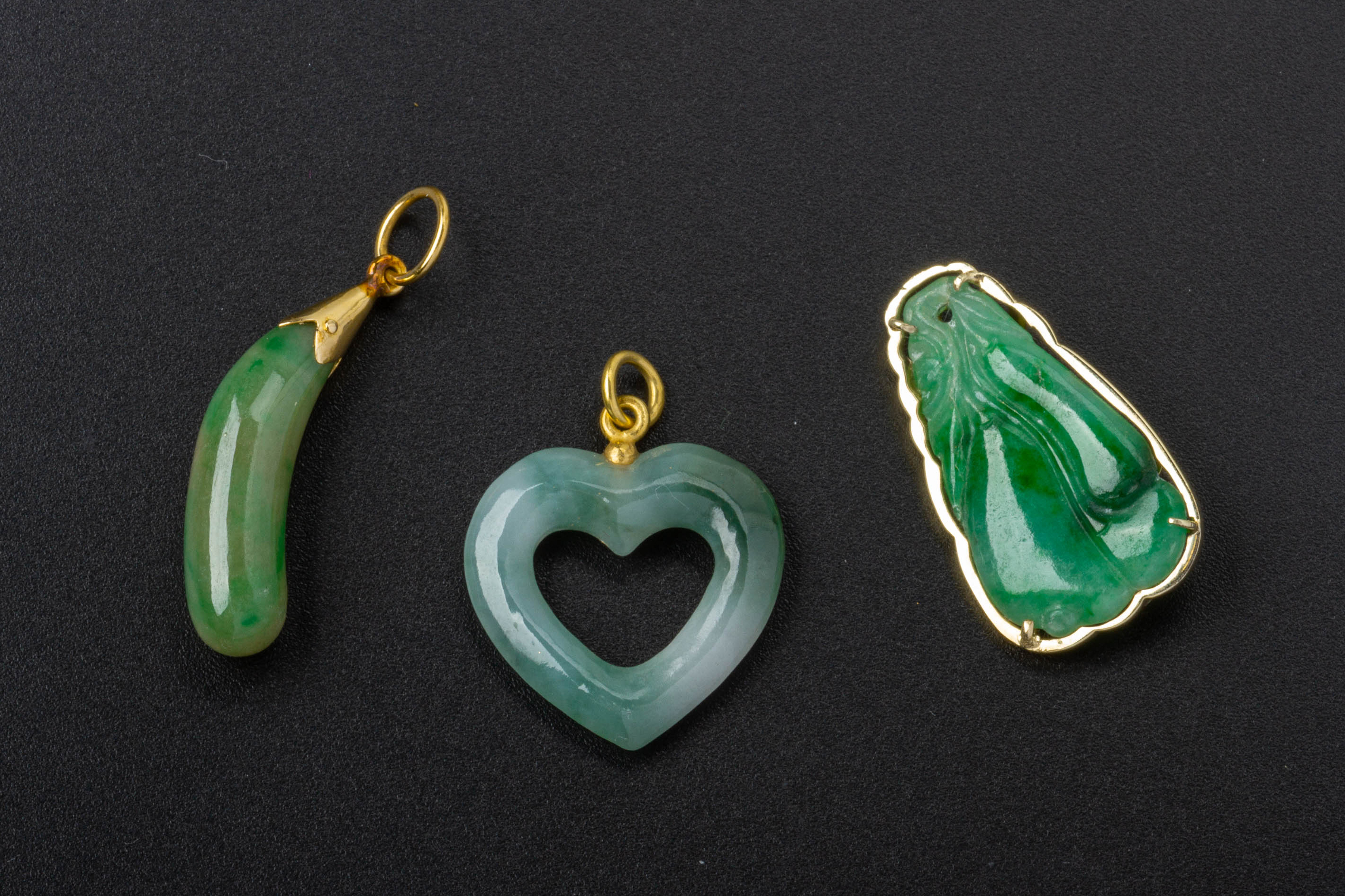 A GROUP OF THREE JADE PENDANTS