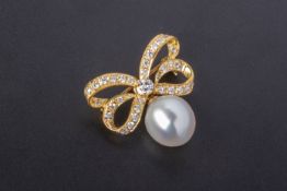 A CULTURED PEARL AND DIAMOND RIBBON SHAPED BROOCH