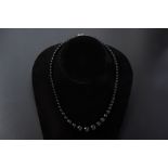 A GRADUATED BLACK GEMSTONE NECKLACE AND EARRING SET