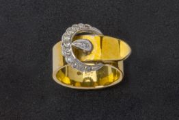 A GOLD AND DIAMOND BUCKLE DESIGN RING