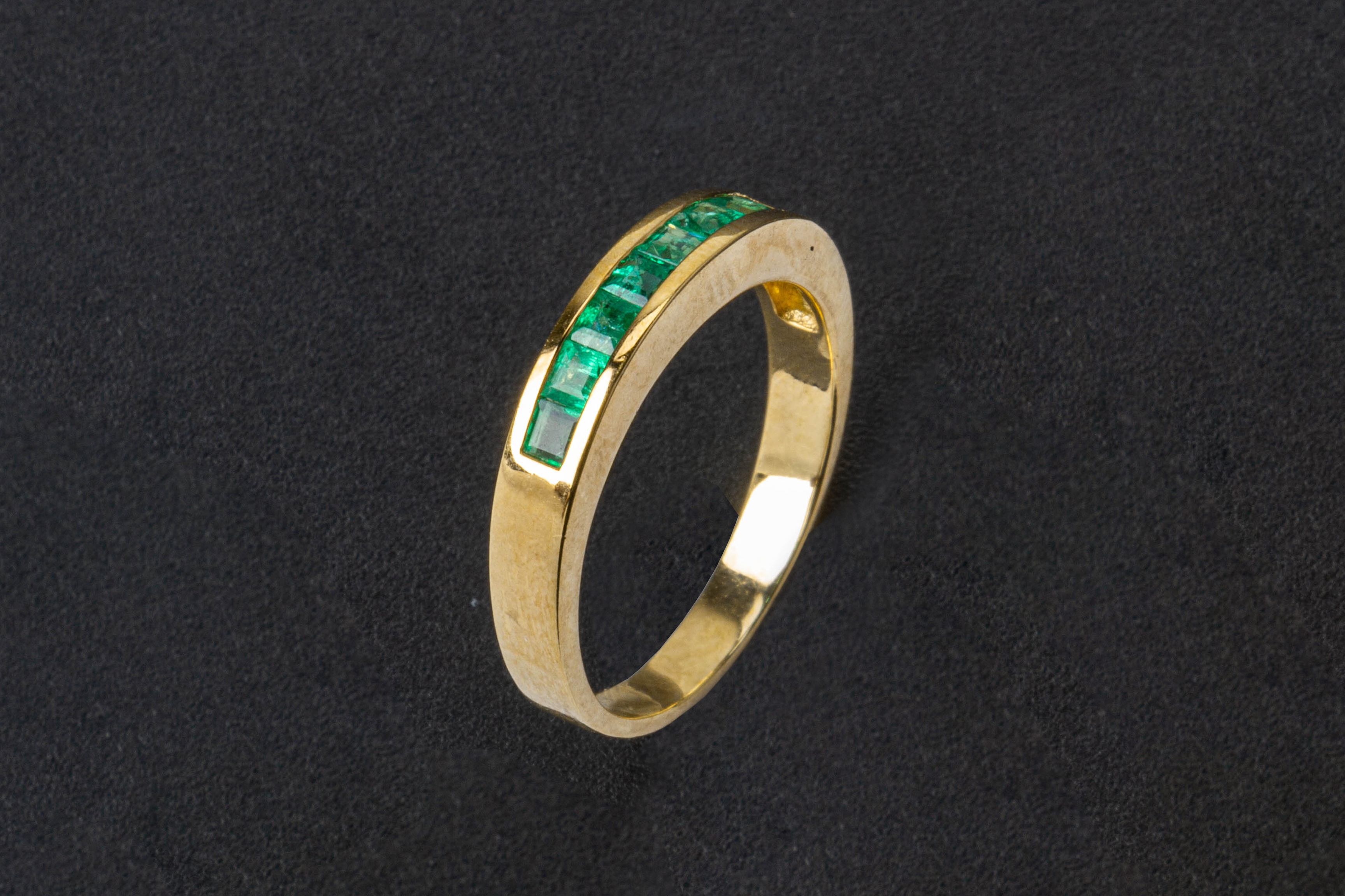 AN EMERALD HALF ETERNITY RING