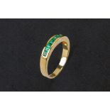 AN EMERALD HALF ETERNITY RING