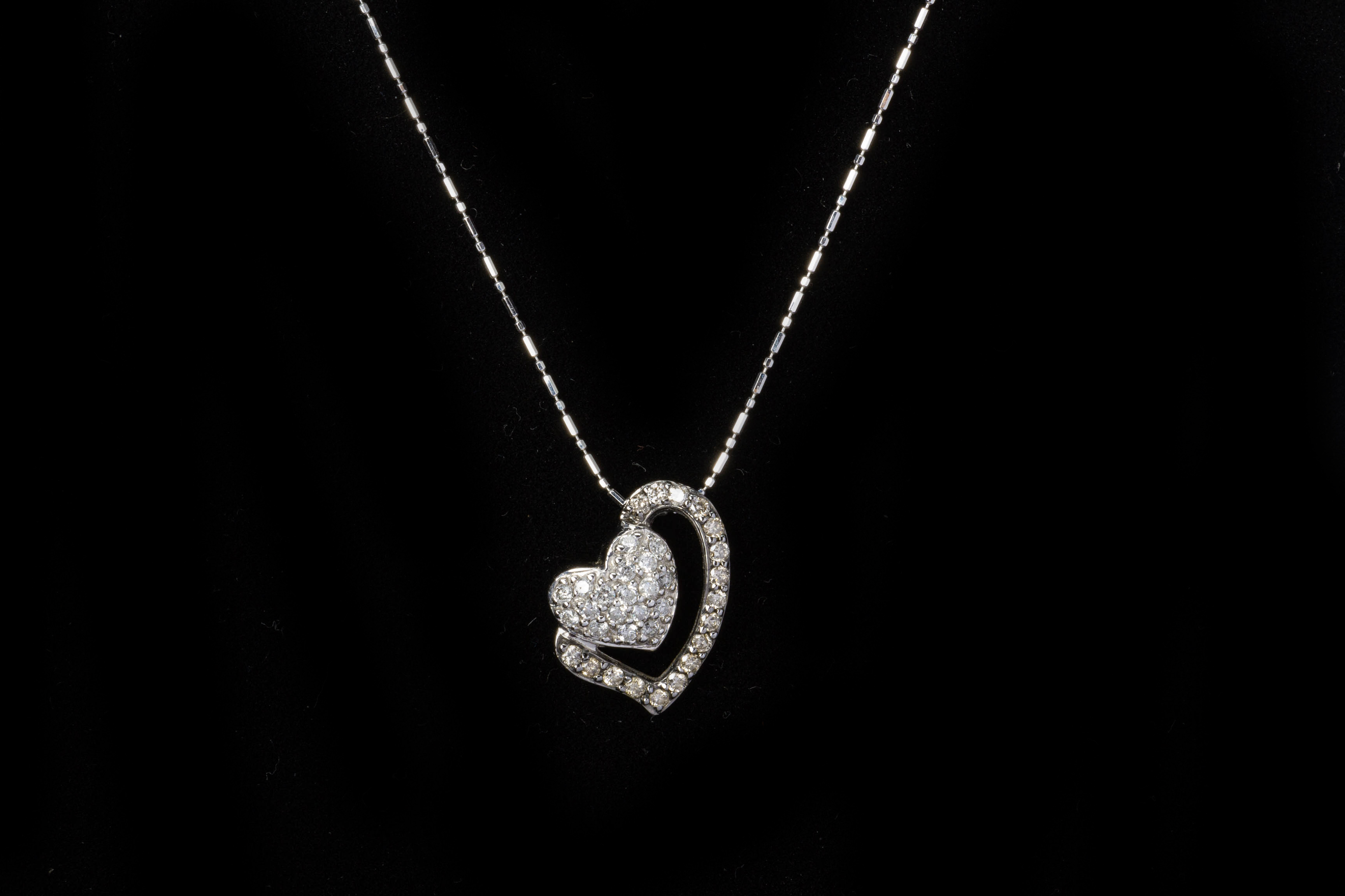 A DIAMOND HEART SHAPED PENDANT ON CHAIN