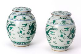 A PAIR OF GREEN ENAMELLED OVOID PORCELAIN JARS AND COVERS