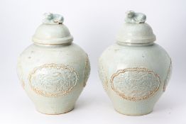 A PAIR OF LARGE PALE GREEN GLAZED JARS AND COVERS