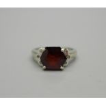 A 9ct white gold ring set with garnet and white topaz, 4g, N