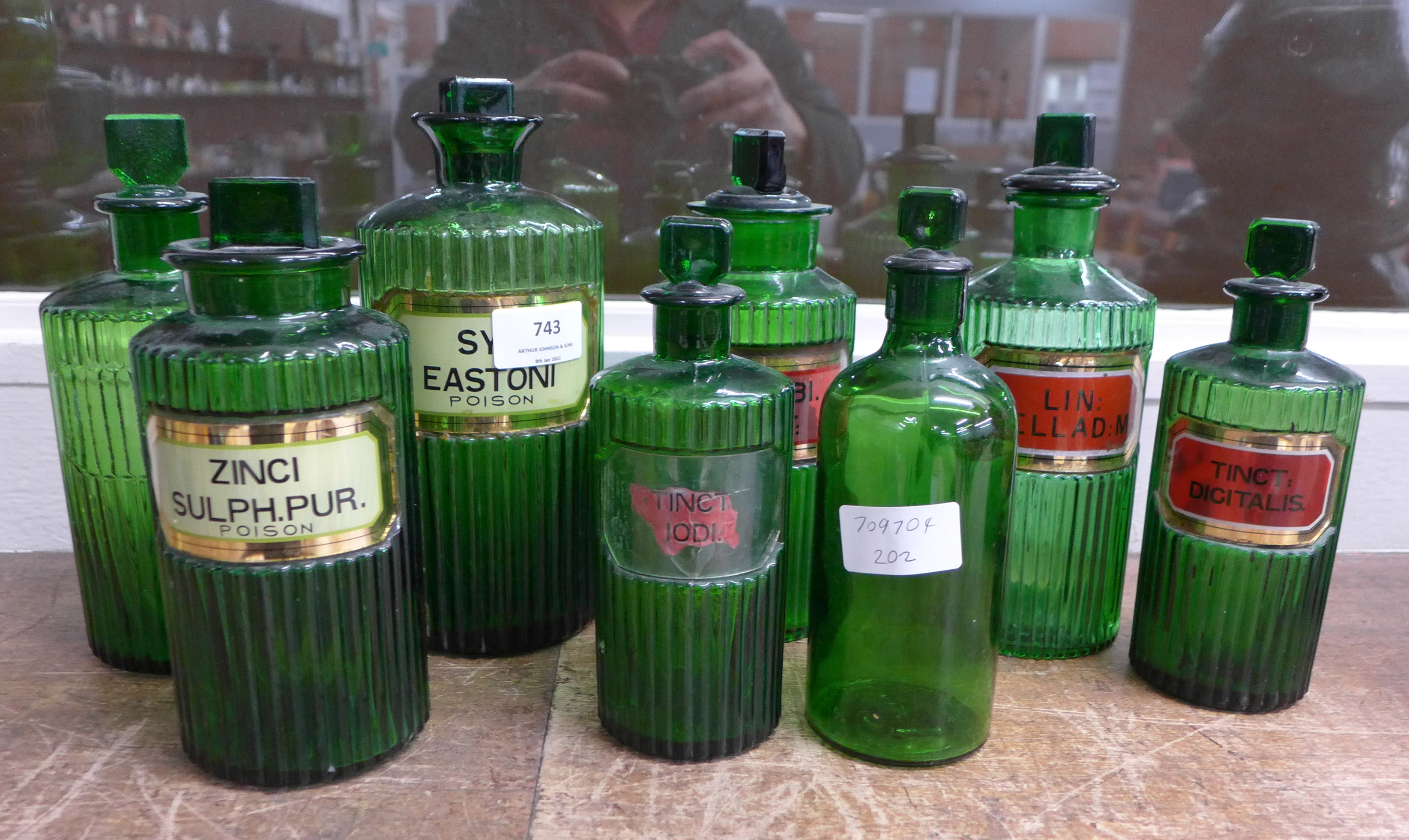 Eight green glass poison and chemist's bottles