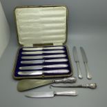 A cased set of silver handled knives, three other silver handled knives, a silver handled button