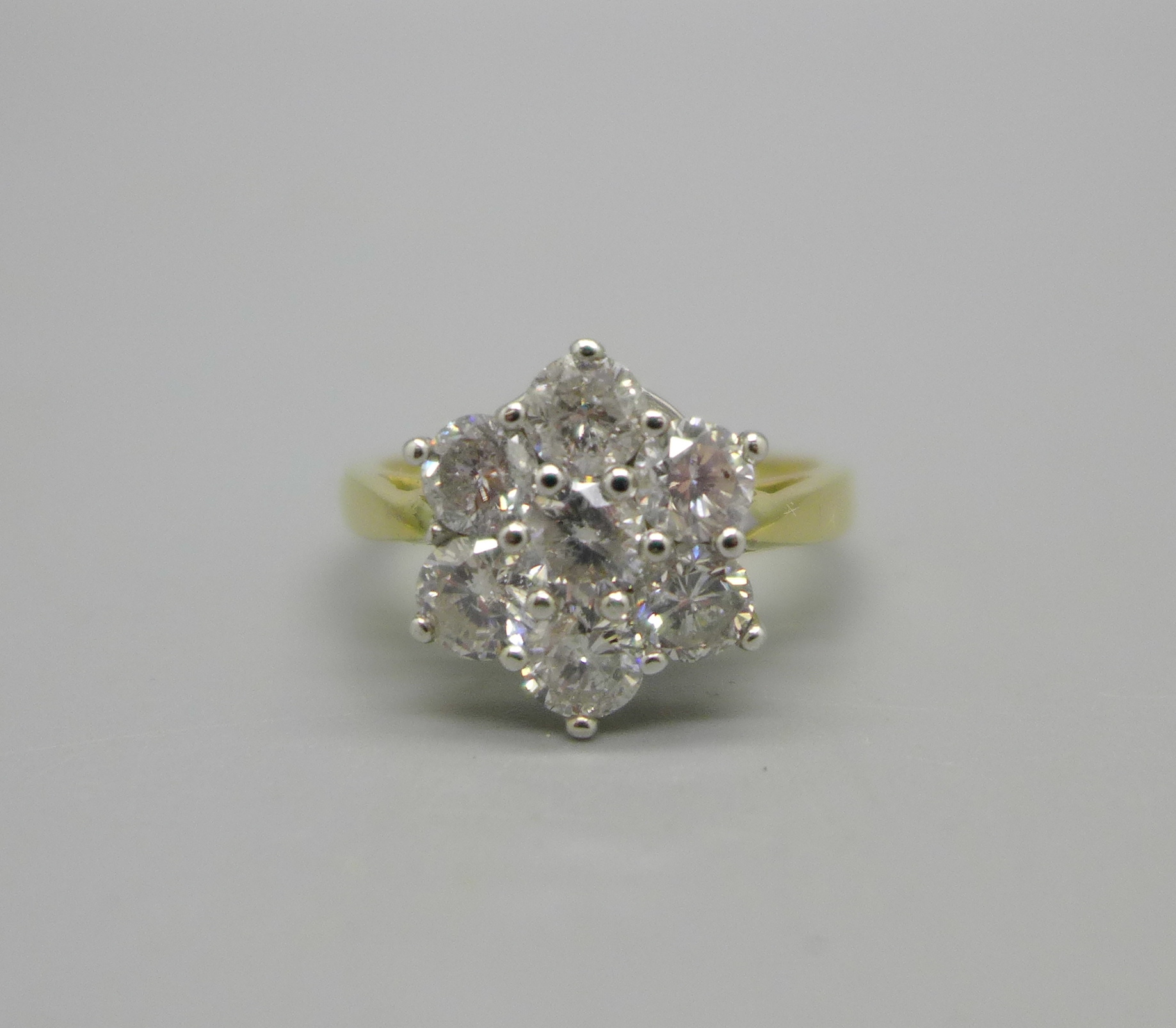 An 18ct gold, seven stone diamond cluster ring, stamped 2ct to the band, 5.1g, P