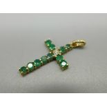 A 9ct gold, diamond and emerald set cross pendant, 23mm