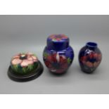 A small Moorcroft ginger jar, lid restored, small vase and paperweight