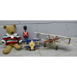 A vintage Teddy bear, a tin-plate model of a bi-plane and two wooden toys