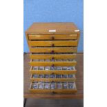 A vintage beech eight drawer printers cabinet, containing printers type