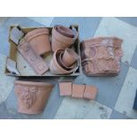 Assorted small terracotta plant pots and two wall pockets