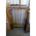 A walnut single door display cabinet