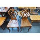 A pair of Victorian carved oak armorial hall chairs