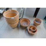 A set of four terracotta plant pots and other pots