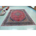 A fine hand knotted Persian Mashad rug, 390 x 297cms