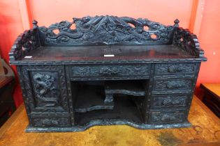 A Chinese carved ebonised desk top cabinet