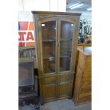 A carved oak freestanding corner cabinet