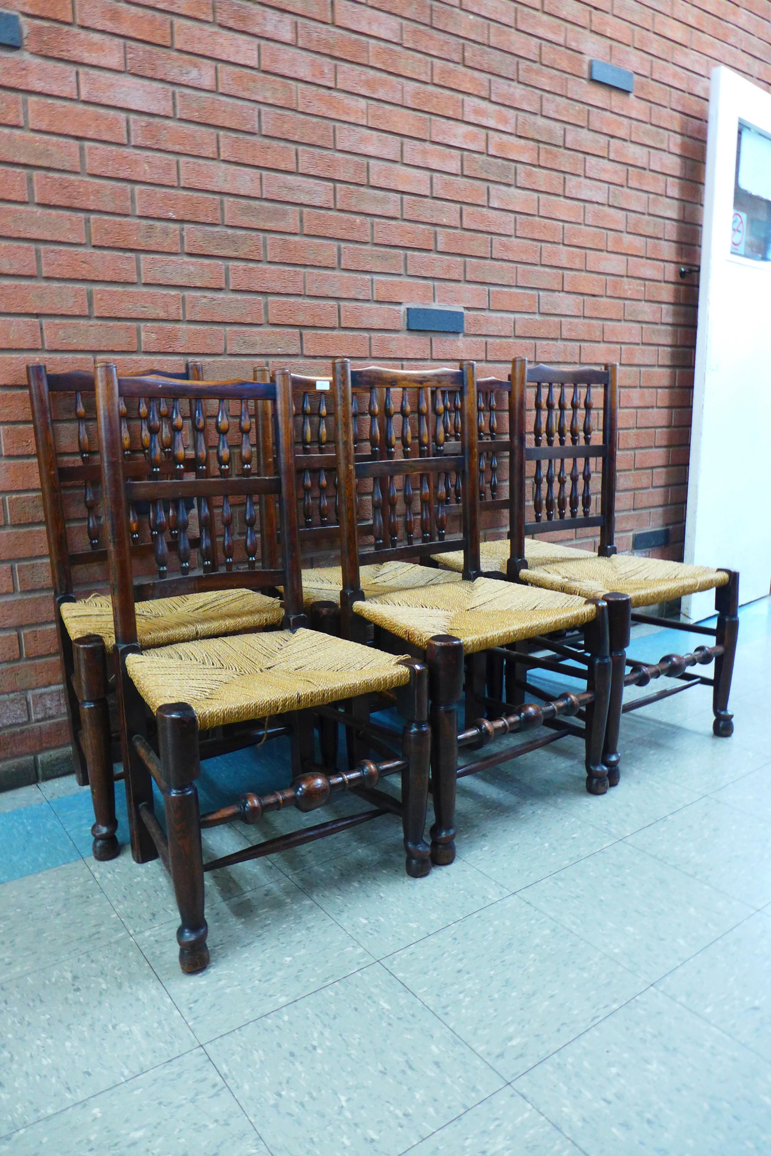 A set of six Georg III style elm and ash spindle back rush seated chairs