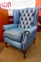 A mahogany and blue leather Chesterfield wingback armchair