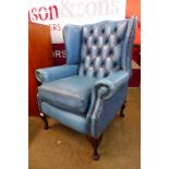 A mahogany and blue leather Chesterfield wingback armchair