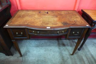 An Edward VII mahogany and leather topped bow centre writing table