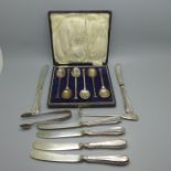 A cased set of six silver spoons, 64g, six butter knives, etc.