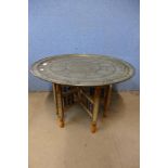 An Indian brass topped folding table