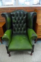 A green leather Chesterfield wingback armchair