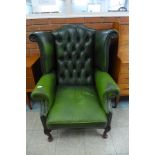 A green leather Chesterfield wingback armchair