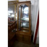 A hardwood pyramid shaped display cabinet