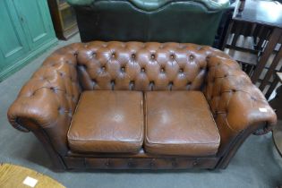 A brown leather Chesterfield settee