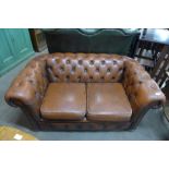 A brown leather Chesterfield settee