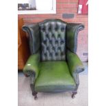 A green leather Chesterfield wingback armchair