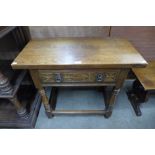 A carved oak single draw side table